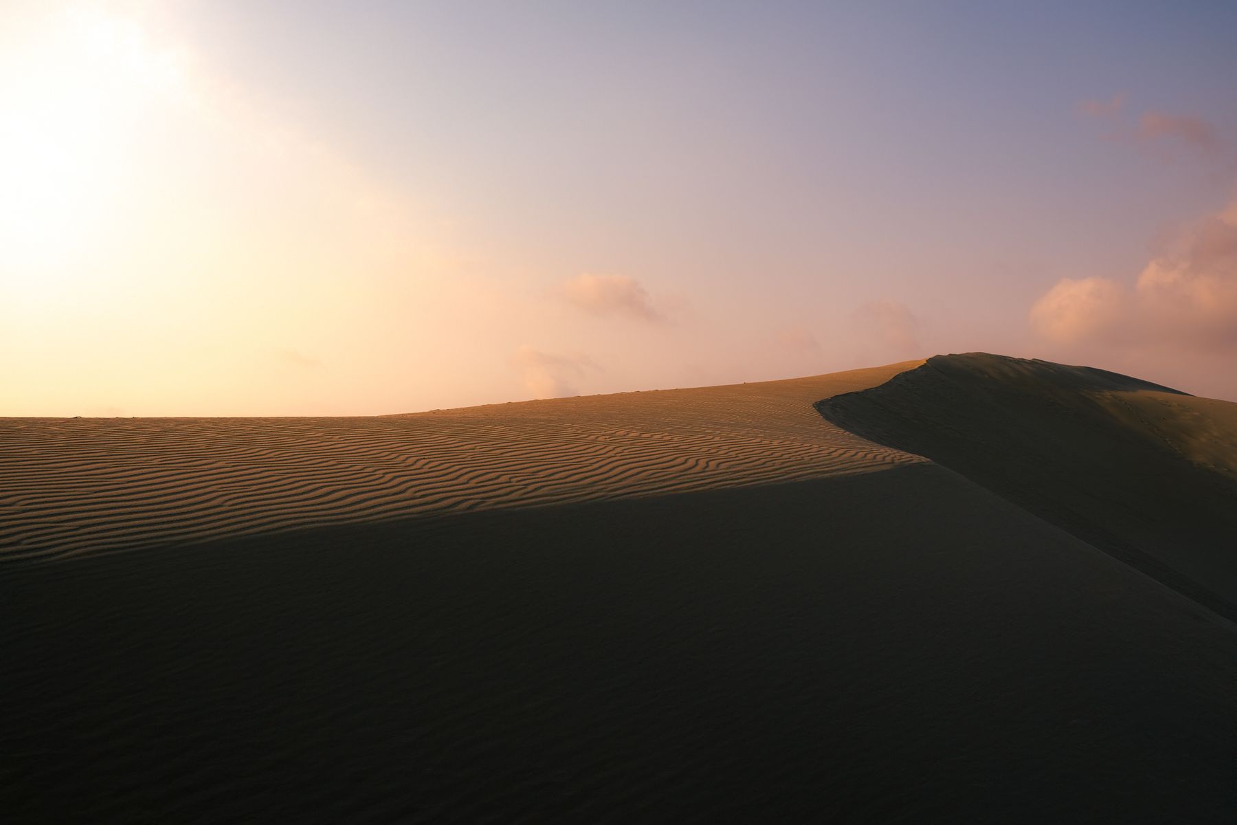 Golden sand dunes rippled by wind at sunset in the Taklamakan Desert